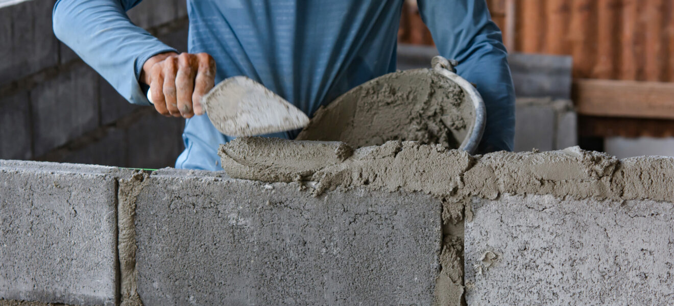 Bricklayer laying bricks on mortar