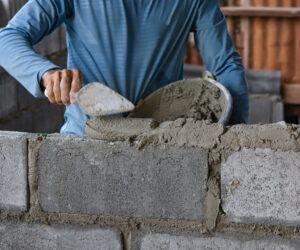 Bricklayer laying bricks on mortar
