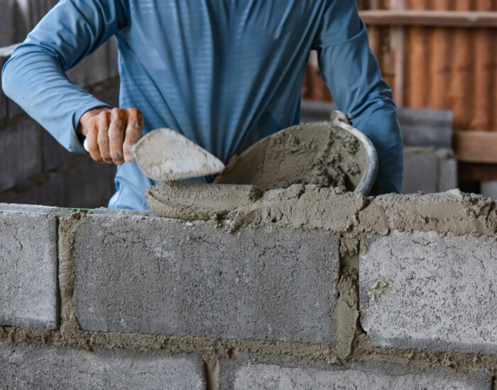 Bricklayer laying bricks on mortar