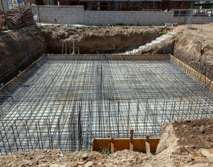 Foundation reinforcement with steel rebar grid, preparing for concrete pouring at building construction site